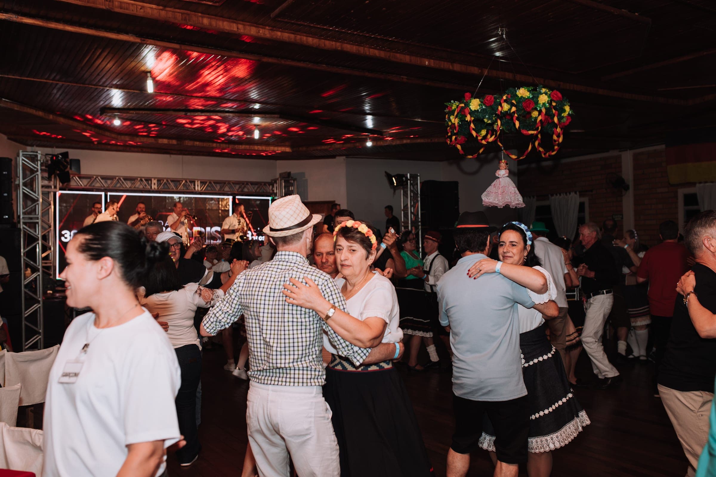 Salão cheio, com o público dançando junto com o grupo
