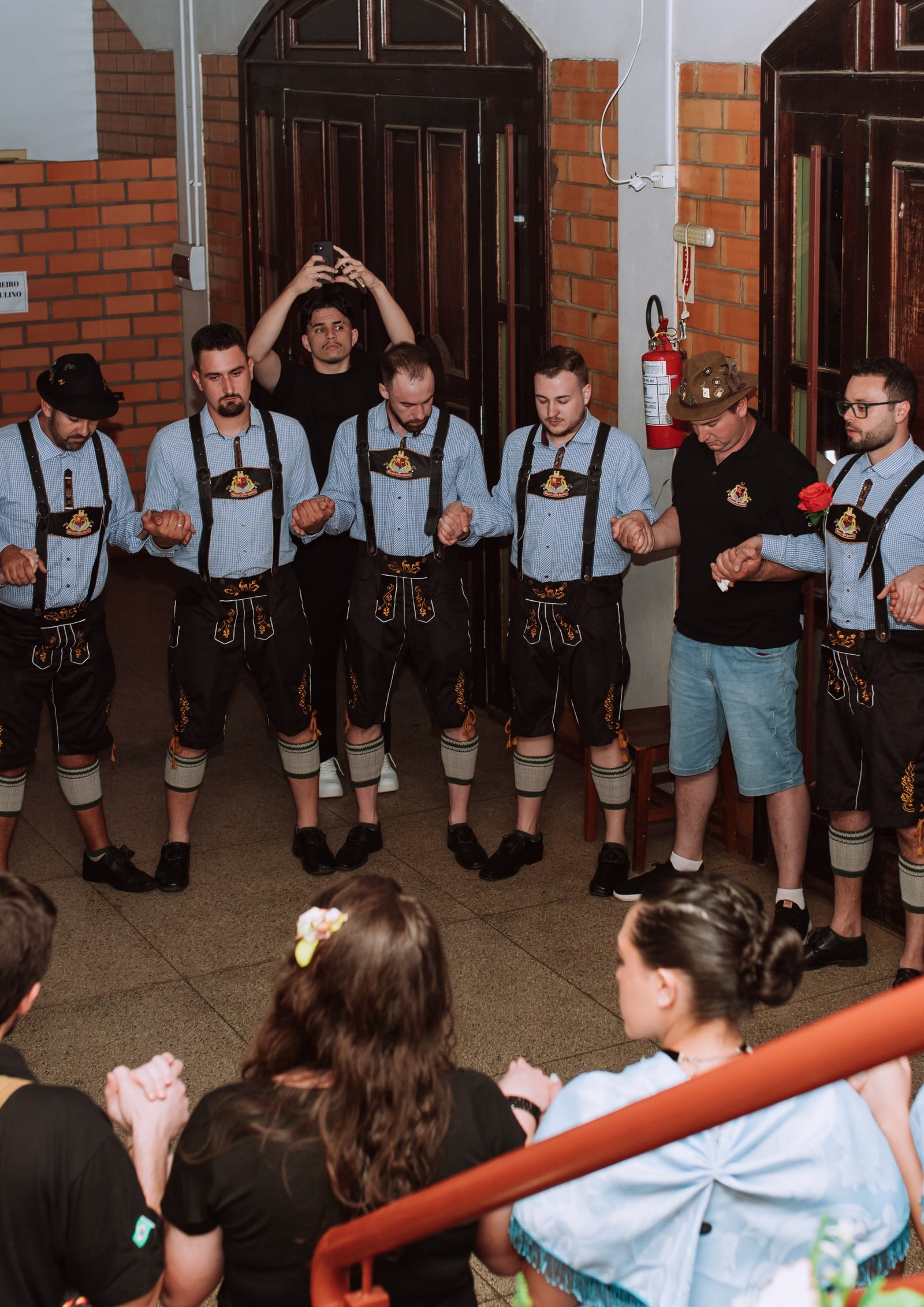 Integrantes do Tanzgruppe Rothenburg reunidos em círculo antes da apresentação, de mãos dadas